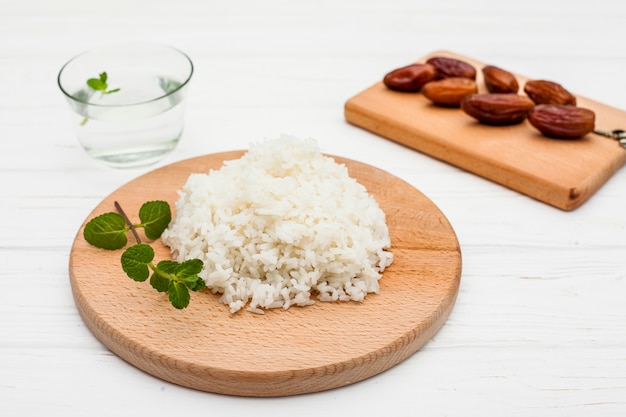 Photo cooked rice with dates fruit on wooden board