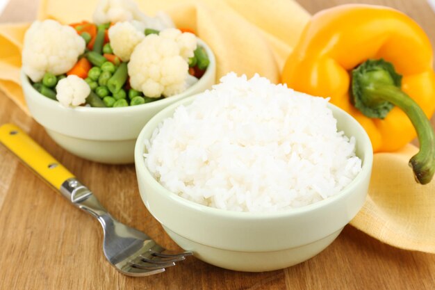 Cooked rice with vegetables on wooden table close up