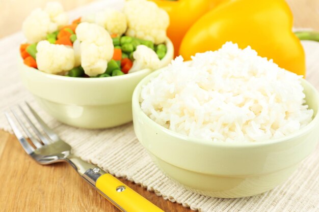 Cooked rice with vegetables on wooden table close up