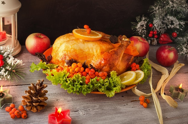 Cooked roasted Turkey with berries vegetables and apples on wooden table background