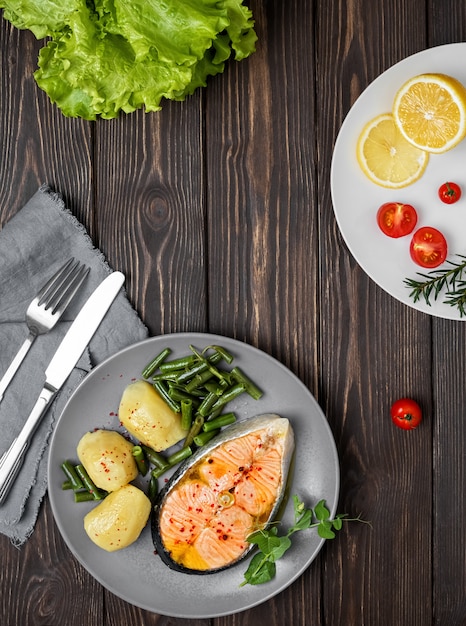 Cooked salmon steak with potatoes and green beans on a plate