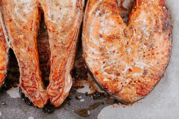 Приготовленные стейки из лосося на противне крупным планом. Стейки красной жареной рыбы. Кусочки запеченного лосося