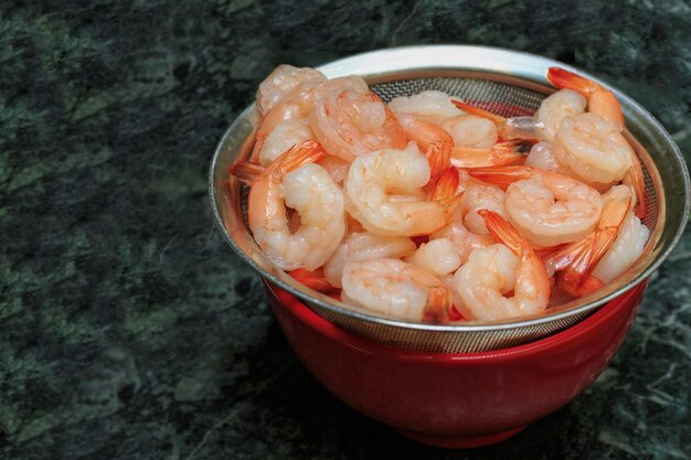 Photo cooked shrimp lying in a sieve on piala