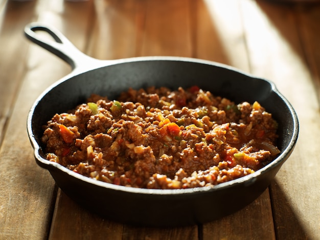 Cooked sloppy joe mix in iron skillet made with ground beef