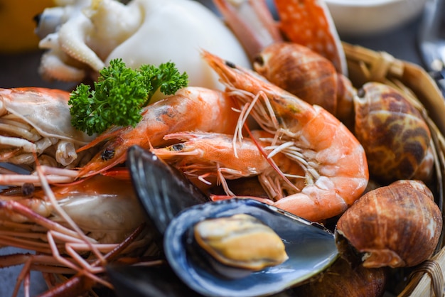 Photo cooked steamer food served seafood buffet concept - fresh shrimps prawns squid mussels spotted babylon shellfish crab and seafood sauce lemon on plate background