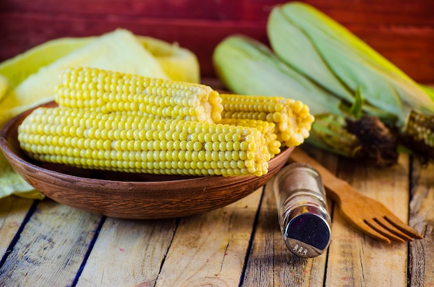 Photo cooked sweet young corn on a plate and salt