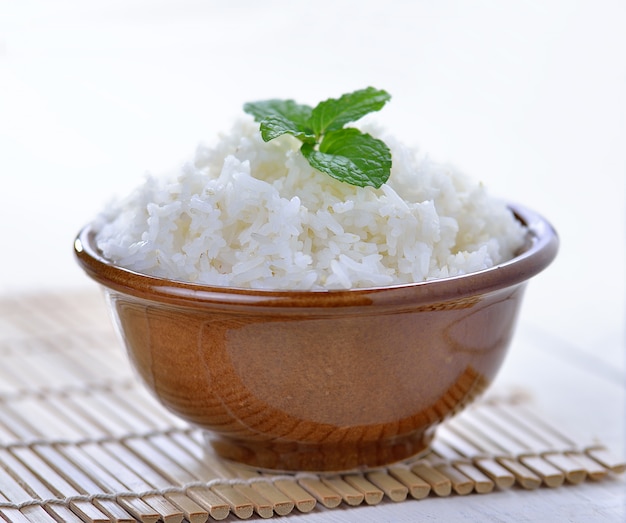 Cooked white rice garnished with mint in a ceramic bowl