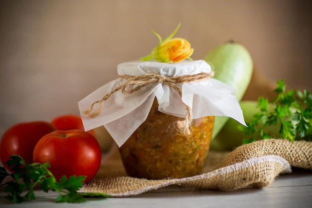 Cooked zucchini caviar with tomatoes in a glass jar preservation