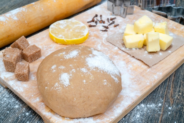 Cookie dough. on the kitchen table. Ingredients - butter, lemon, flour, sugar, cloves.