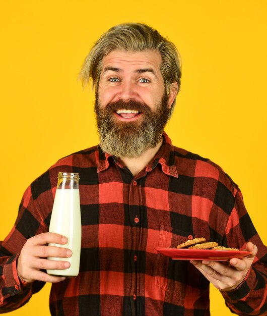 Cookie and a glass of milk. happy farmer eat cookie dessert. bearded man drink useful milk with pastry. Better together for valentines day. man eating cookies and drinking milk.