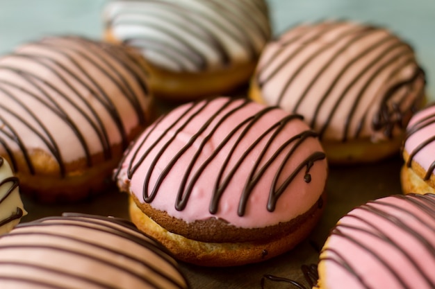 Cookie sandwiches with icing. Biscuits decorated with chocolate. Creamy glaze of pink color. Bush cakes for dessert.