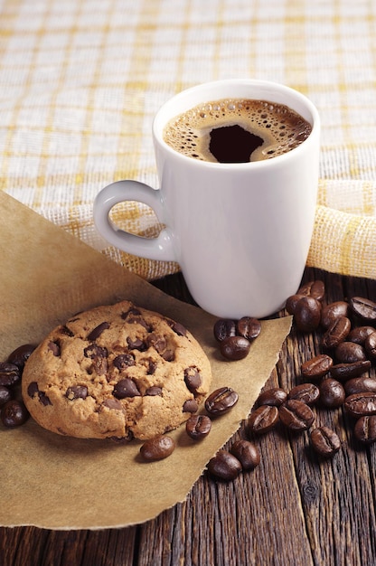 Cookie with chocolate and coffee on dark wooden table covert tablecloth