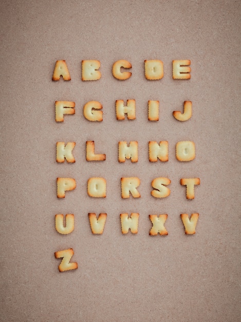 Cookies ABC in the form of alphabet A-Z on brown cardboard background