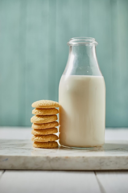 Foto biscotti con latte in bottiglia su tavola