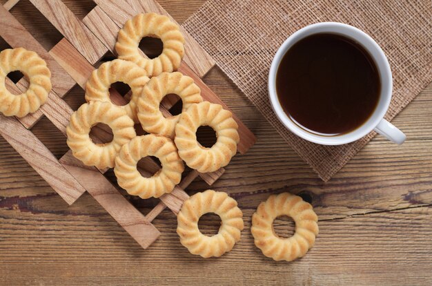 Cookies and coffee on wooden background, top view