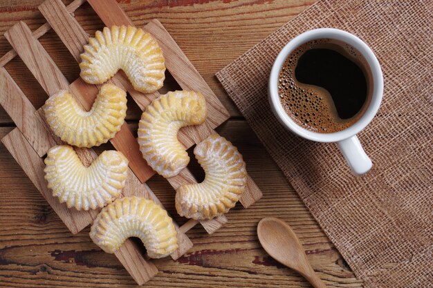 Cookies and coffee on the wooden table, top view