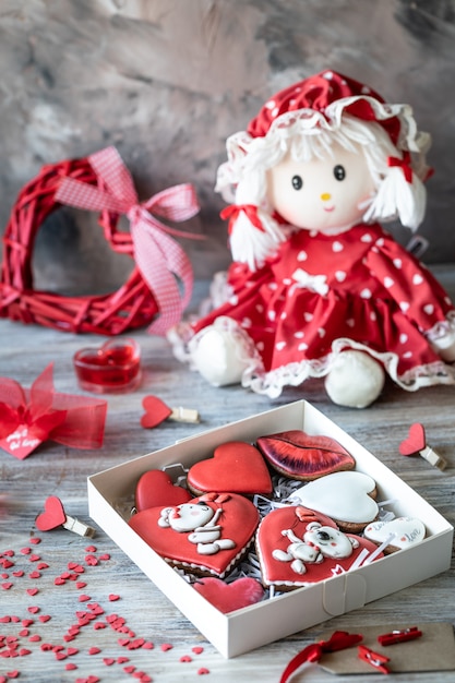 Cookies or gingerbread cookies in a gift box with a red ribbon on a wooden table.