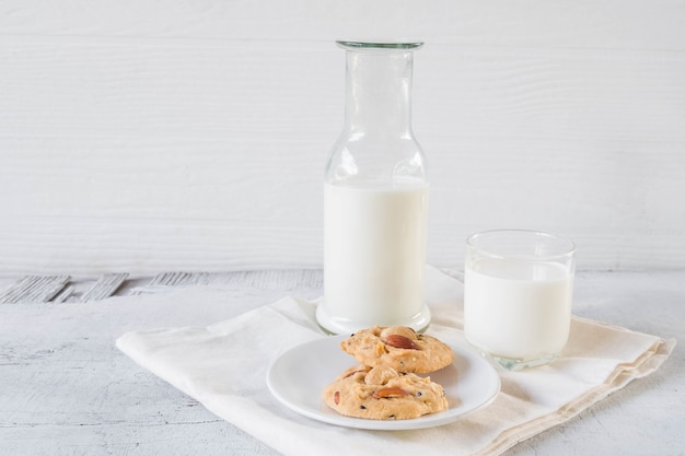 Cookies and milk on white wooden background