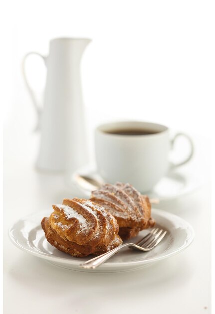 Foto biscotti nel piatto e tazza di caffè sul tavolo