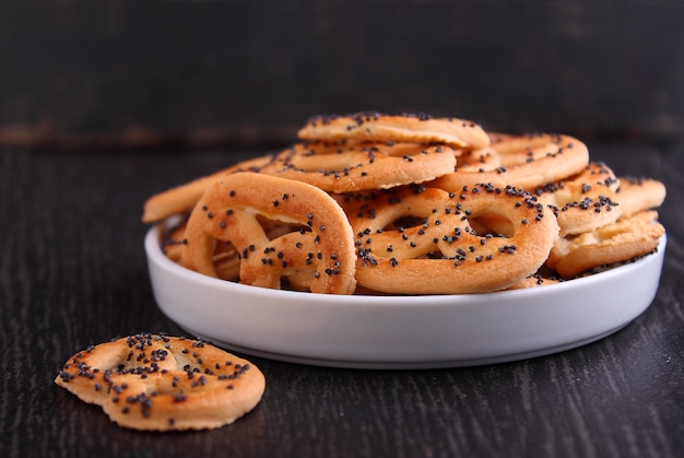 Cookies pretzels with poppy seeds on a black background