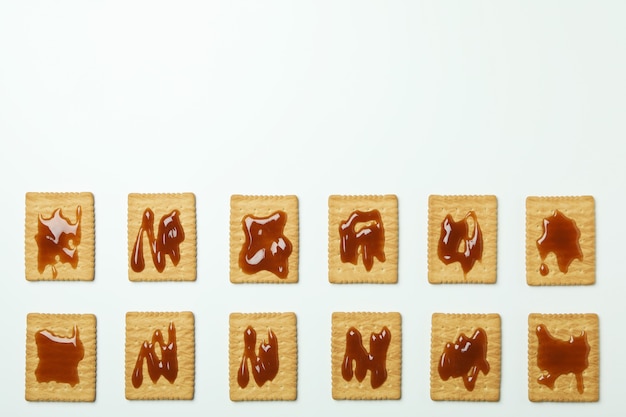 Cookies with caramel on white background, top view