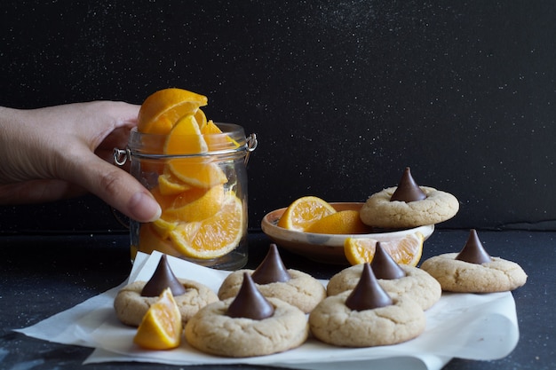 Cookies with chocolate candy, sliced orange pieces .