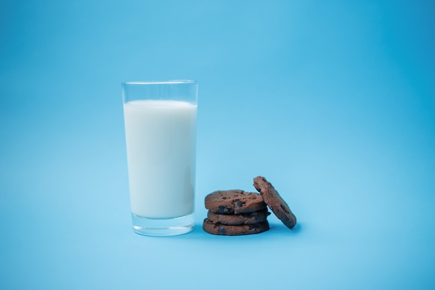 Cookies with chocolate chips on a plate on a table and a glass of milk