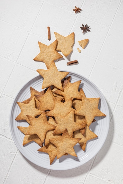 Cookies with cinnamon in the form of stars on a plate on a white background for the New Year