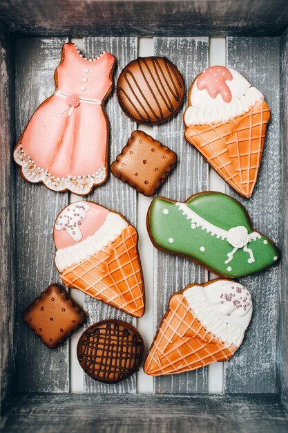 Cookies with kitchen mastic in a wooden box. round and square cookies. ice cream in a waffle cone.