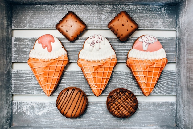 Cookies with kitchen mastic in a wooden box. round and square cookies. ice cream in a waffle cone.