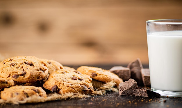 Cookies with pieces of milk chocolate with a glass of milk