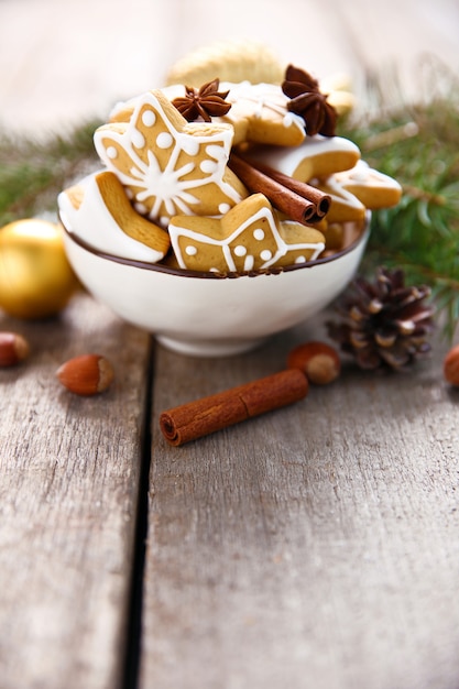 Biscotti con spezie e decorazioni natalizie, su tavola di legno