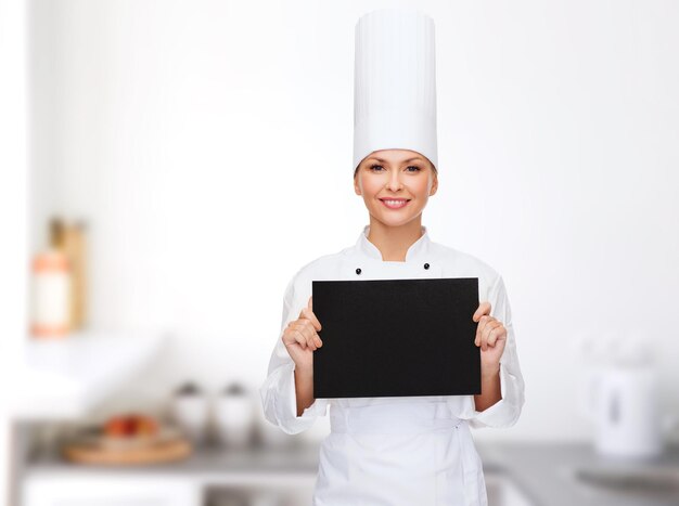 cooking, advertisement and food concept - smiling female chef with blank black paper