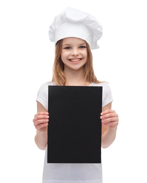 cooking, advertisement and food concept - smiling little chef, cook or baker with blank black paper