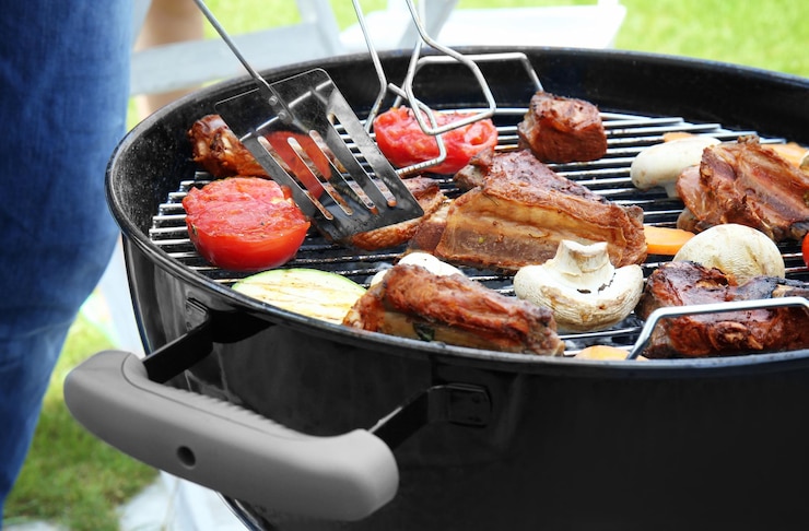 Photo cooking of appetizing juicy spare ribs and vegetables outdoors