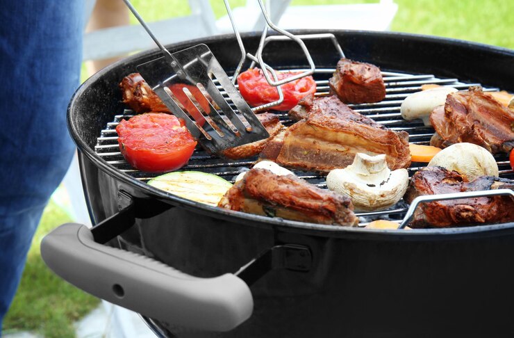Photo cooking of appetizing juicy spare ribs and vegetables outdoors