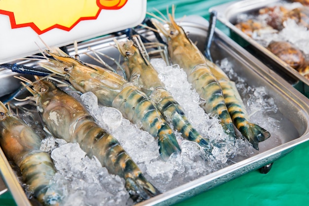 사진 요리, 아시아 주방, 판매 및 음식 개념 - 거리 시장에서 얼음 위에 얹은 차가운 새우 또는 해산물