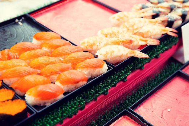 cooking, asian kitchen, sale and food concept - sushi sets at street market