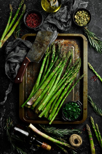 Cooking asparagus Green asparagus with spices on the table Healthy food On a stone background Top view