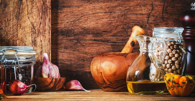 Foto sfondo di cottura tavolo da cucina in legno rustico padella in ghisa smerigliatrici per spezie tagliere vasetti per la conservazione di spezie e condimenti spazio di copia