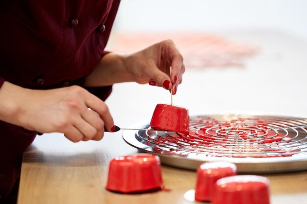 Photo cooking, baking and confectionery concept - chef serving mirror glaze cakes at pastry shop