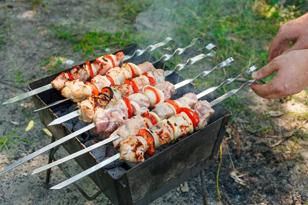 Cooking barbecue with vegetables on skewers Roasted meat on the grill closeup