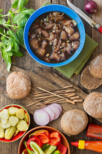 Cooking burgers with vegetables and meat on a wooden table