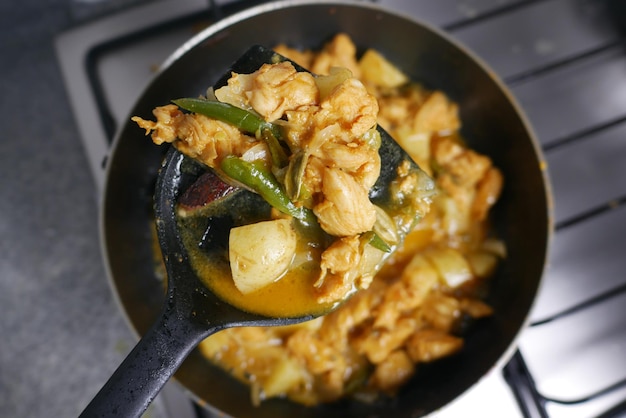 Cooking chicken curry in a cooking pan