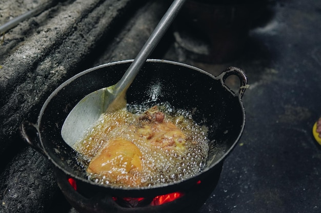 전통적 인 주방 에서 고기 고기 를 는 기름 에 담아 요리 하는 것