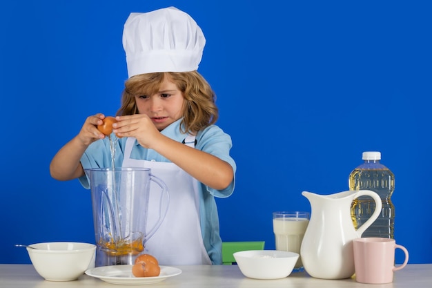 Фото Кулинарные дети шеф-повар мальчик делает свежие овощи для здорового питания портрет маленького ребенка в
