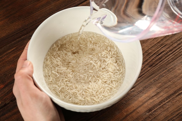 Cooking concept Pouring water in bowl with rice