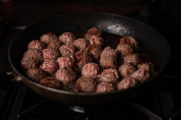 프라이팬에 맛있는 수제 쇠고기 미트볼 요리하기 어두운 배경 미트볼