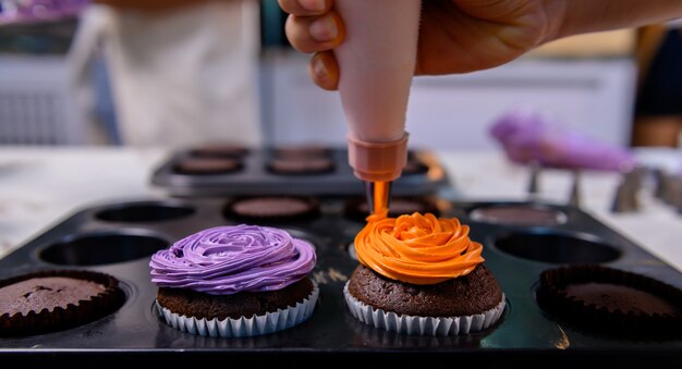 Cooking delicious homemade cake and decorate cupcake for Halloween festive. Preparing and mixing ingredients for sweet food dessert in kitchen at home.