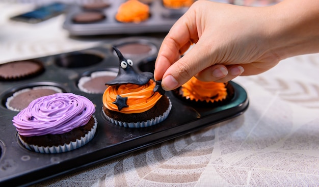 Cooking delicious homemade cake and decorate cupcake for Halloween festive. Preparing and mixing ingredients for sweet food dessert in kitchen at home.